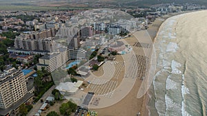 aerial view of beach with umbrellas down, sand and sea waves landscape