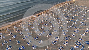 aerial view of beach with umbrellas down, sand and sea waves landscape