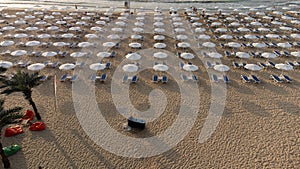 aerial view of beach with umbrellas down, sand and sea waves landscape