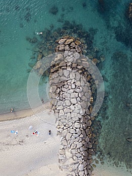 Aerial view of a beach and umbrellas. Tropea, Calabria, Italy. Parghelia. Beach and rocks of Lido La scogliera