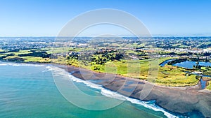 Aerial view on a beautiful bridge across a small river with residential suburb and Tasman sea on the background. New Zealand