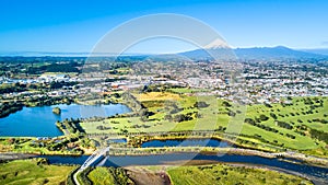 Aerial view on a beautiful bridge across a small stream with Mount Taranaki on the background. New Zealand