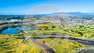 Aerial view on a beautiful bridge across a small stream with Mount Taranaki on the background. New Zealand