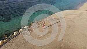 Aerial view beautiful fit girl looks at boundless ocean before workout