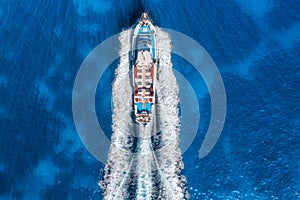Aerial view of beautiful floating yacht in blue sea at sunny day