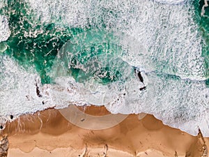 Aerial view of a beautiful Guincho beach with Atlantic Ocean waves rolling on the shoreline at twilight, Cascais, Portugal