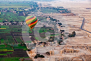 Aerial view of beautiful hot air balloon flying over the ruins Temple of the Ramesseum