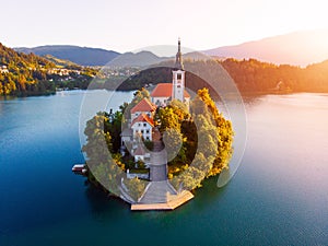 Aerial view of beautiful Lake Bled in the middle of the charming little island and the wonderful church at autumn sunrise