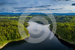 Aerial view of beautiful lake with islands and green forests in mountains on a sunny summer day in Pilchowice