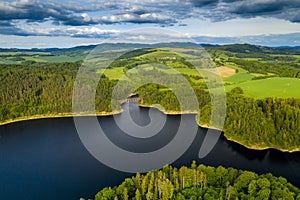 Aerial view of beautiful lake with islands and green forests in mountains on a sunny summer day in Pilchowice