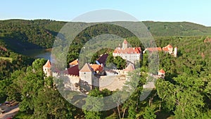 Aerial view of beautiful, Moravian royal castle Veveri or Burg Eichhorn, standing on a rock above water dam on river Svratka. Larg