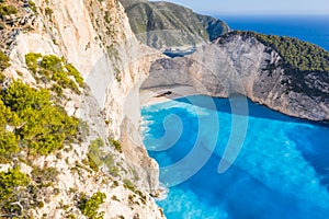 Aerial view of beautiful Navagio or Shipwreck beach on Zakynthos Island, Greece. Tourists on cliff edge enjoy view on