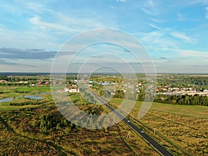 Aerial view beautiful panoramic landscape golden sunset above the forest. The road goes beyond the horizon in the rays of the sun