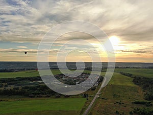 Aerial view beautiful panoramic landscape golden sunset above the forest. The road goes beyond the horizon in the rays of the sun