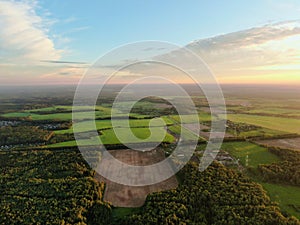 Aerial view beautiful panoramic landscape of green forest and fields against the backdrop of sky and clouds at sunset in summer