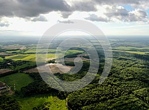 Aerial view beautiful panoramic landscape of green forest and fields against the backdrop of sky and clouds at sunset in summer