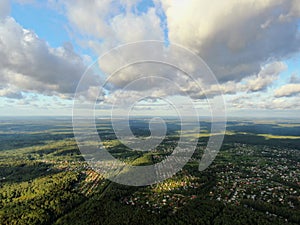 Aerial view beautiful panoramic landscape of green forest and fields against the backdrop of sky and clouds at sunset in summer