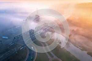 Aerial view of beautiful railroad bridge and river in fog in fall