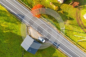 Aerial view of beautiful road in green hills at sunset in autumn