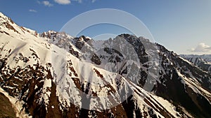 Aerial view of beautiful snowy mountains in Kyrgyzstan. Mountain peaks, summit. Beautiful untouched nature. Travel