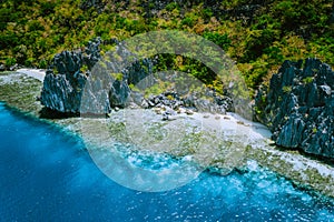 Aerial view of beautiful tropical limestone rocks, blue ocean and coral reef edge at El Nido, Palawan, Philippines