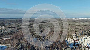 Aerial view of beautiful winter forest, roads and trees covered with snow in sunny day. Motion. Gorgeous winter scenery