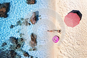 Aerial view of the beautiful woman with pink swim ring on the se