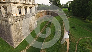 Aerial view of a beautiful young couple standing at the castle. 4k