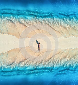 Aerial view of the beautiful young lying woman on the sandy beac