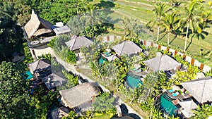 Aerial view of beautifully landscaped recreation house cottage complex with pond in ecological area on bright sunny day