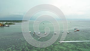 Aerial view of Benoa Beach in Bali. There are many tourists doing water sports.