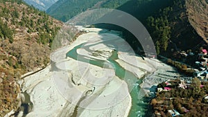 Aerial View of Bhagirathi River surrounded by Shape of Sands,Apple orchards,Houses,Green Forest and Brown Mountains