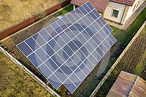 Aerial view of big blue solar panel installed on ground structure near private house