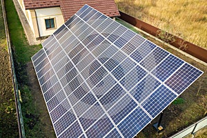 Aerial view of big blue solar panel installed on ground structure near private house