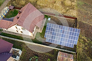 Aerial view of big blue solar panel installed on ground structure near private house