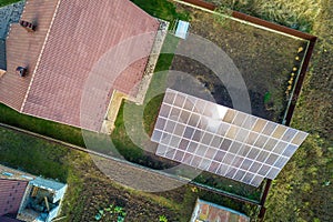 Aerial view of big blue solar panel installed on ground structure near private house