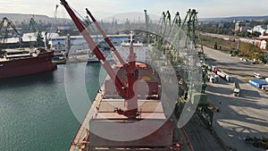 Aerial view of big cargo ship bulk carrier is loaded with grain of wheat in port at sunset