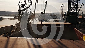 Aerial view of big cargo ship bulk carrier is loaded with grain of wheat in port at sunset