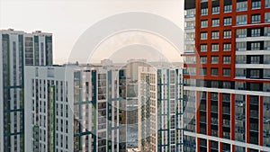 Aerial view of a big city district with sunny streets and high rise residential buildings on cloudy sky background