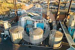 Aerial view of big fuel reservoirs in petroleum industrial zone and metal exhaust pipes of oil refinery factory