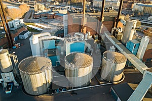 Aerial view of big fuel reservoirs in petroleum industrial zone and metal exhaust pipes of oil refinery factory