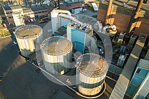 Aerial view of big fuel reservoirs in petroleum industrial zone and metal exhaust pipes of oil refinery factory