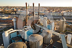 Aerial view of big fuel reservoirs in petroleum industrial zone and metal exhaust pipes of oil refinery factory