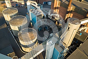 Aerial view of big fuel reservoirs in petroleum industrial zone and metal exhaust pipes of oil refinery factory