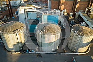 Aerial view of big fuel reservoirs in petroleum industrial zone and metal exhaust pipes of oil refinery factory