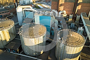 Aerial view of big fuel reservoirs in petroleum industrial zone and metal exhaust pipes of oil refinery factory