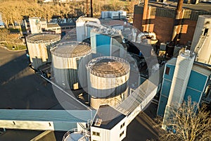 Aerial view of big fuel reservoirs in petroleum industrial zone and metal exhaust pipes of oil refinery factory