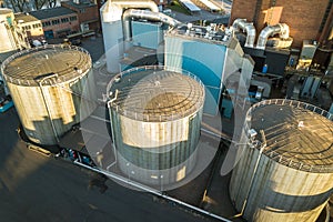 Aerial view of big fuel reservoirs in petroleum industrial zone and metal exhaust pipes of oil refinery factory