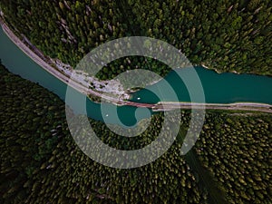 Aerial view of big metal railway bridge across river, in the middle of summer forest.