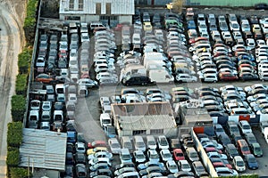 Aerial view of big parking lot of junkyard with rows of discarded broken cars. Recycling of old vehicles